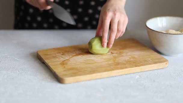 Closeup of a woman cutting with a knife peeled green kiwi. Healthy Breakfast, meals - Felvétel, videó