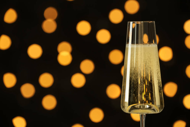 Glass of champagne against blurred lights. Space for text - Foto, immagini