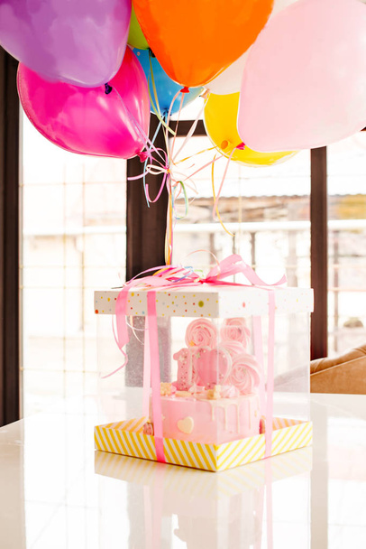  pastel rosa en la celebración del primer cumpleaños de la niña, globos y felicitaciones, 1 año
 - Foto, Imagen