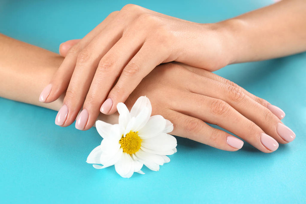 Closeup view of woman with flower on color background. Spa treatment - Valokuva, kuva