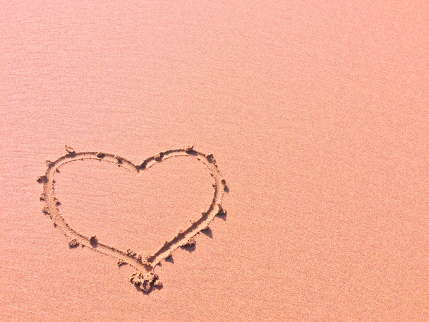 sormi piirretty sydän hiekalla, rakkauden symboli
 - Valokuva, kuva