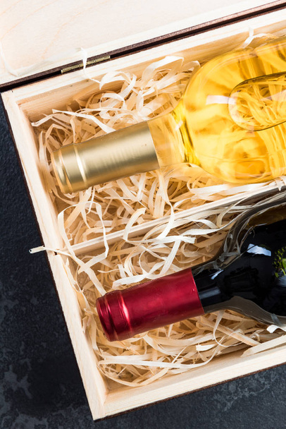 Botellas de vino tinto y blanco en caja de madera vintage
 - Foto, imagen