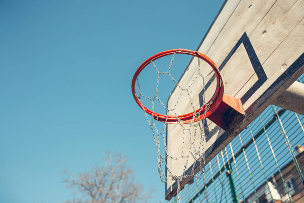 Basketball hoop with backboard in residential district for street basketball game, outdoors sports and recreation, urban environment, retro toned image - Фото, зображення
