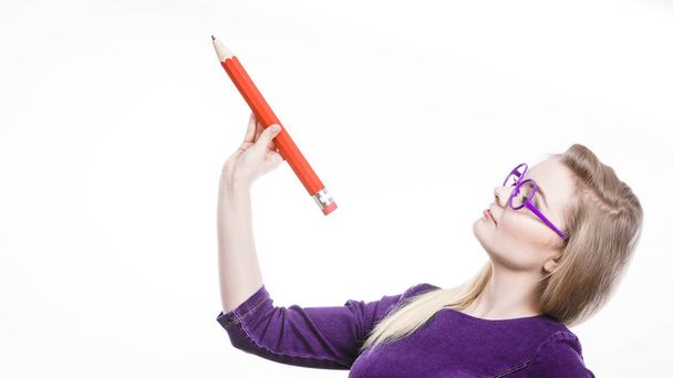 Smiling woman holds big pencil in hand - Foto, Imagem