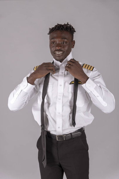 Mladý letecký pilot s africkým účesu. Člen posádky svazoval svou černou kravatu, - Fotografie, Obrázek