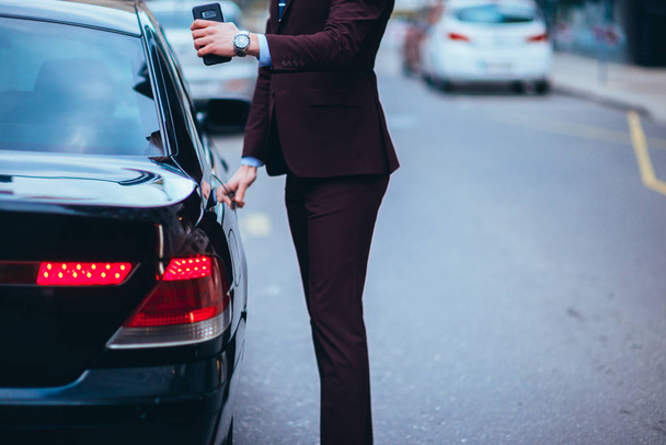 Hommes d'affaires convenables ouvrant la porte arrière de sa limousine
 - Photo, image