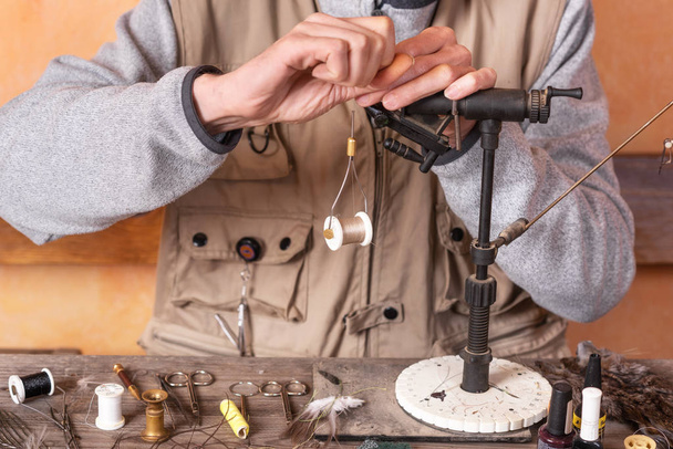 Man making trout flies. Fly tying equipment and material for fly fishing preparation. - Photo, Image