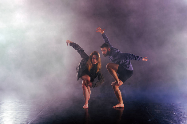 Dos bailarines modernos estiran sus pies sin zapatos alto en el ai
 - Foto, Imagen