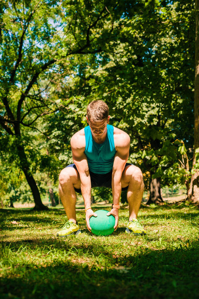 Entraîneur de fitness faisant de l'exercice dans la nature avec la boule de médecine
 - Photo, image