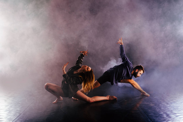 pareja de danza moderna torciendo sus piernas y lening cerca de la
  - Foto, imagen