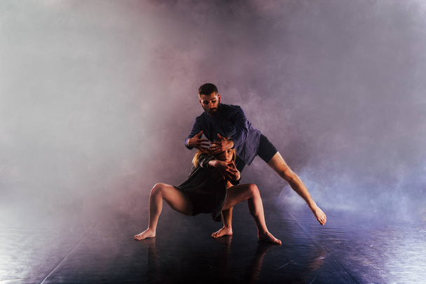 Deux danseurs modernes étirant leurs pieds sans chaussures haut dans l'ai
 - Photo, image
