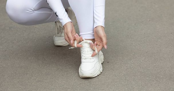 Young woman runner tying shoelaces with copy space, healthy lifestyle and sport concepts. - Fotografie, Obrázek
