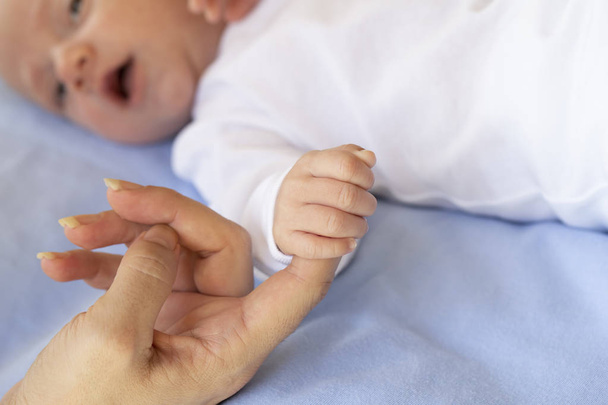 Kisbaba, aki az anya ujját - Fotó, kép