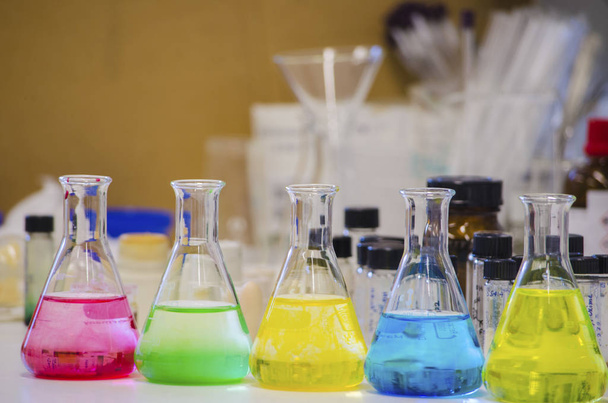 Multiple colorful solution in conical flask lined on a bench in  - Photo, Image