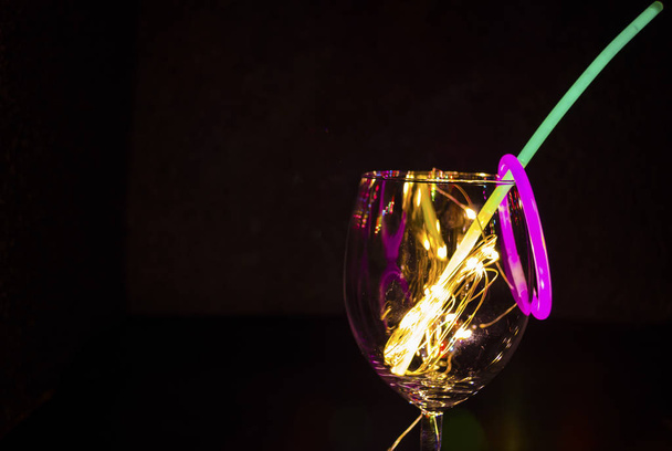 Сине-зеленая лампочка на бокале с новогодним шампанским
 - Фото, изображение