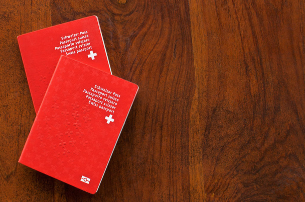 Dwa szwajcarskie paszporty na drewnianym stole - Zdjęcie, obraz