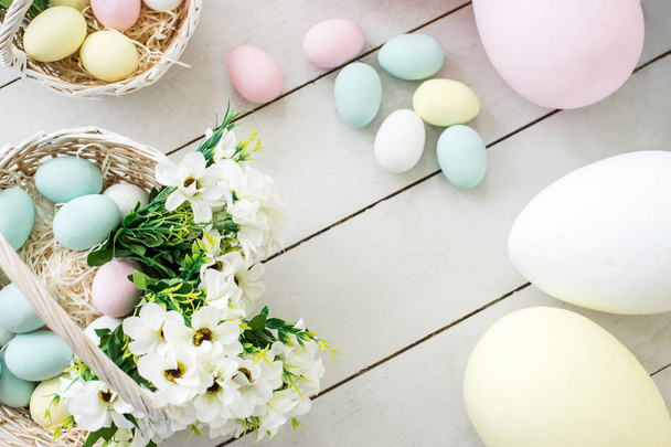 huevos de Pascua de colores y flores en cestas de mimbre. espacio de copia - concepto de Pascua
 - Foto, imagen