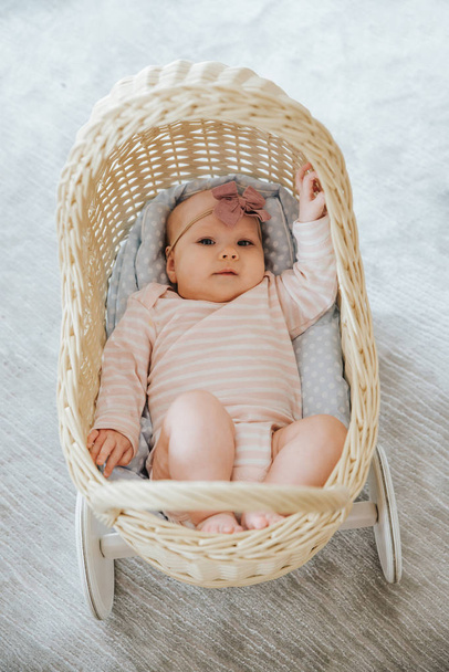 newborn in a toy wicker trolley, top view - Foto, imagen