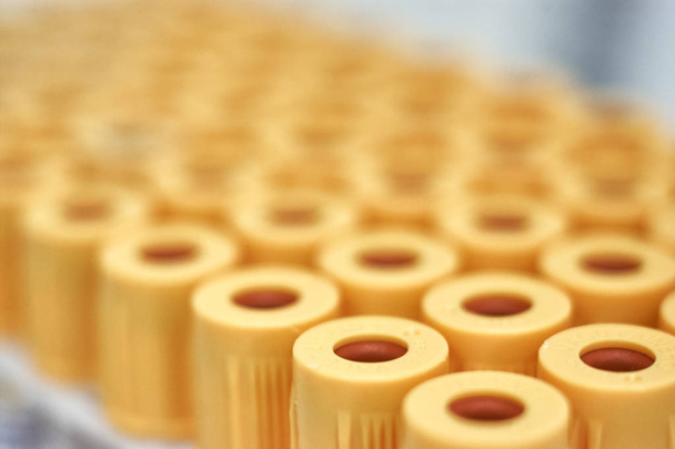 macro de tubos de ensayo con tapa amarilla, contra un gradiente de fondo blanco. Enfoque selectivo
 - Foto, Imagen