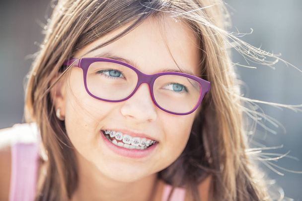 Portrait of happy smiling girl with dental braces and glasses - Photo, image