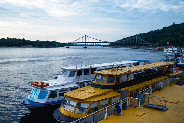 turisztikai csónakok a folyami kikötő hídon a háttérben - Fotó, kép