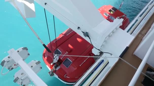 Красная спасательная шлюпка опускается в воду
 - Кадры, видео