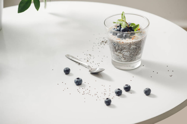 Healthy breakfast or morning snack with chia seeds vanilla pudding and berries on wooden background, vegetarian food, diet and health concept - Photo, image