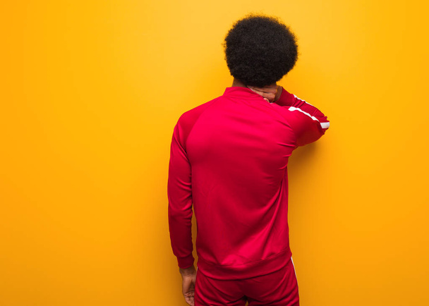 młody sport czarny człowiek nad a pomarańczowy ściana od tyłu myśleć o czymś - Zdjęcie, obraz
