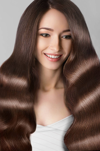 Włosów. Uśmiechnięta piękna kobieta z brązowymi włosami. Fryzurę. Pielęgnacja włosów - Zdjęcie, obraz
