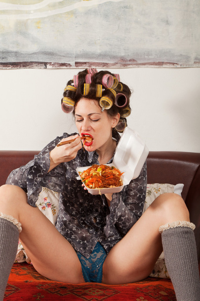 sexy girl eating spaghetti on the couch - Foto, afbeelding