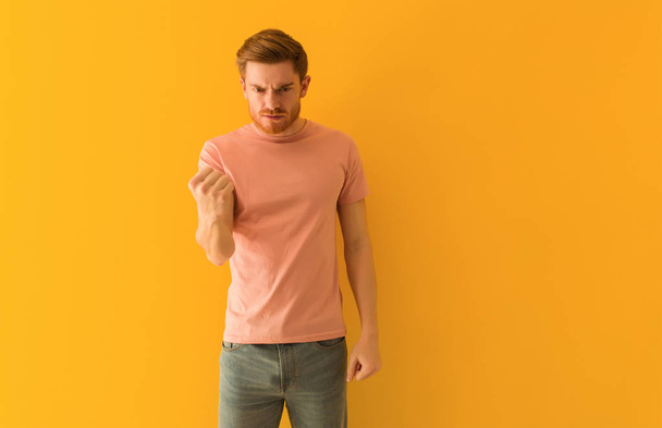Young redhead man showing fist to front, angry expression - Photo, Image