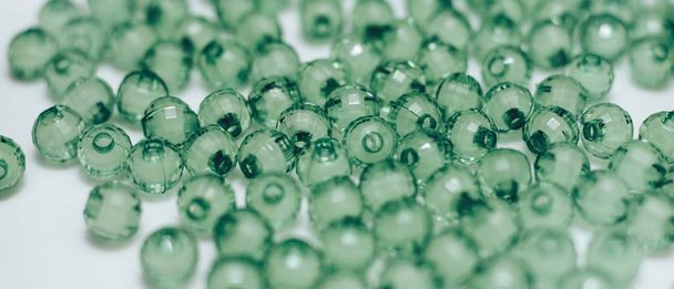 Perles de verre vert sur fond blanc. Vue macro
. - Photo, image