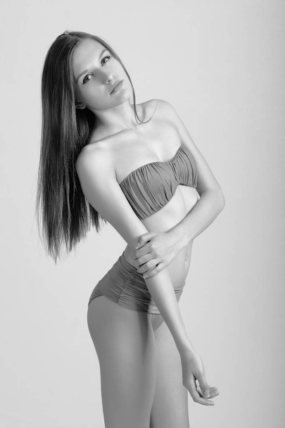 Slim body of young woman in bikini on white . Girl with healthy sporty figure - Фото, зображення