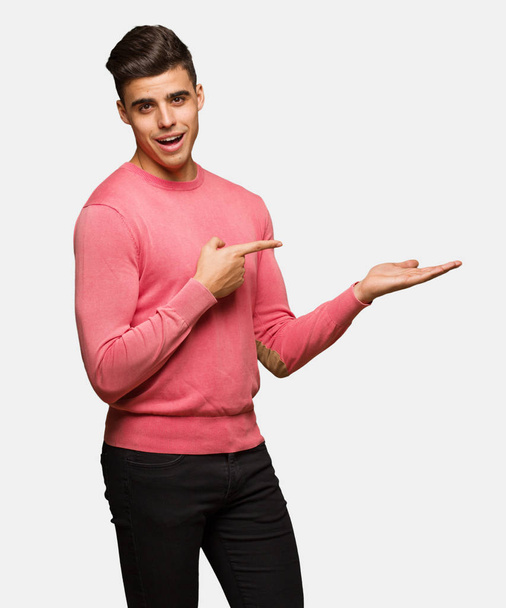 Young funny man holding something with hand - Photo, image