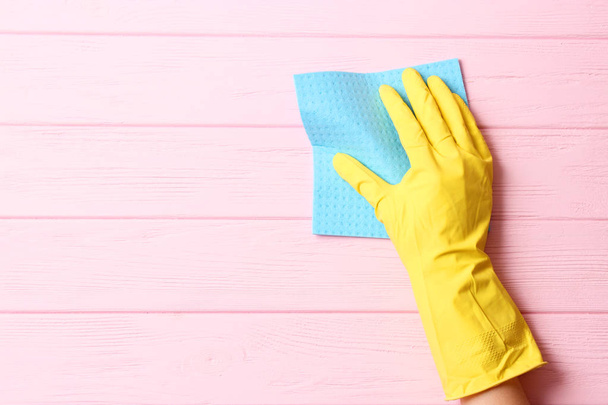 female hand in cleaning glove and rag on colored background - Valokuva, kuva
