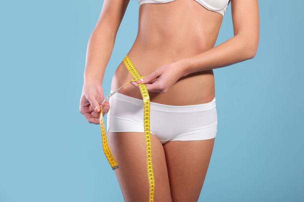 Woman measuring her slim body - Foto, afbeelding