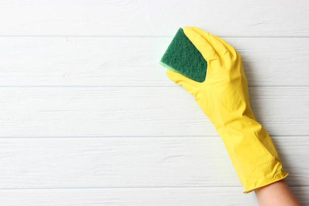 γυναικείο χέρι στον καθαρισμό γάντι και κουρέλι σε χρωματιστό φόντο - Φωτογραφία, εικόνα