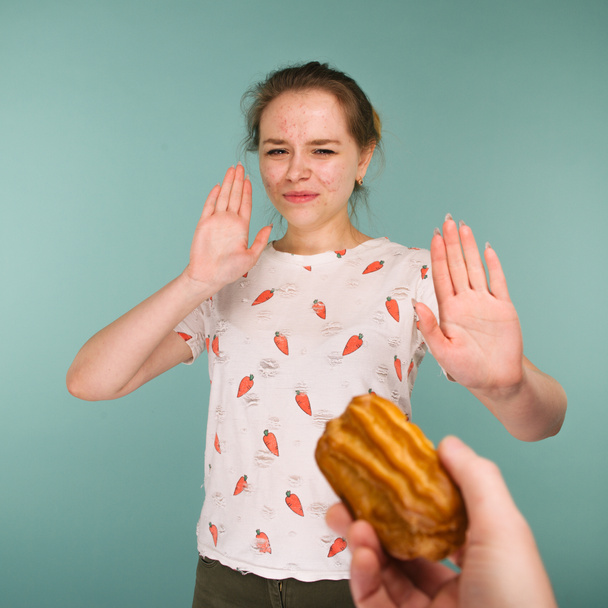 Portrait de jeune fille boutonneuse hows mains arrêter sur un délicieux gâteau
 - Photo, image