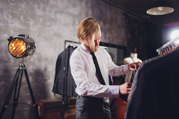 portrait of male client choosing classic jacket in the mall. - Foto, immagini