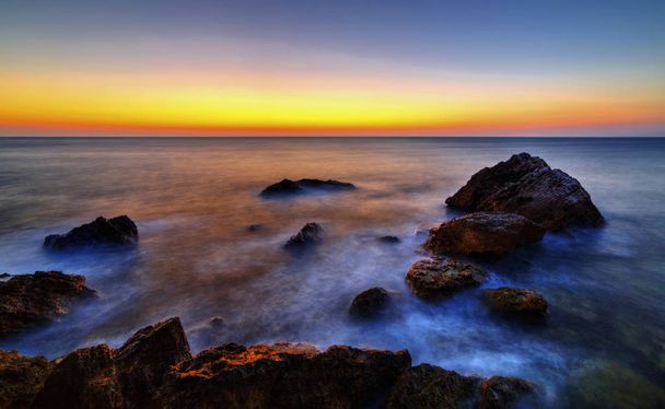 Прекрасний схід сонця над скелястим берегом
 - Фото, зображення