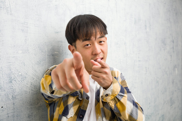 Jeune homme chinois visage gros plan joyeux et souriant pointant vers l'avant
 - Photo, image