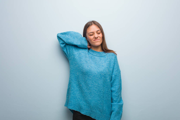 Joven bonita mujer usando un suéter azul que sufre dolor de cuello
 - Foto, imagen