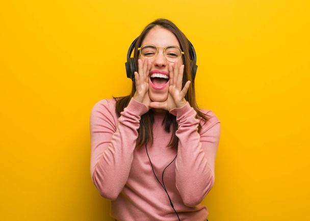 Young cute woman listening to music shouting something happy to the front - Foto, immagini