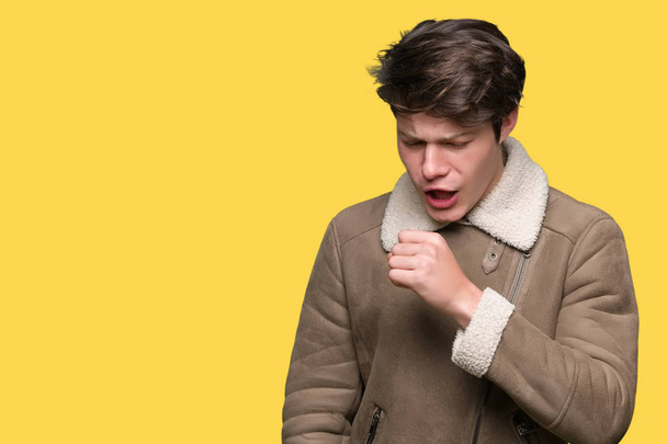 Mladý pohledný muž na sobě zimní kabát přes samostatný pozadí pocit nepohody a kašle jako příznak nachlazení či zánět průdušek. Zdravotnické koncepce. - Fotografie, Obrázek