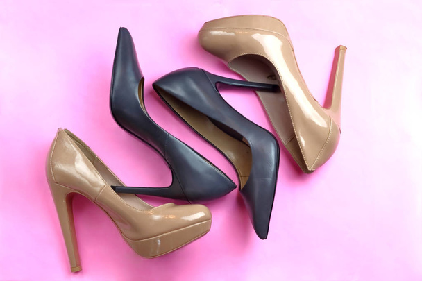 Модна гламурна вишукана група з 2 пар взуття чорний класичний і оголений бежевий рожевий патент глянцева пара елегантних взуття на високих підборах на рожевому фоні
  - Фото, зображення