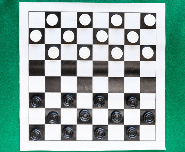 top view of draughts on black and white sheet - Photo, Image