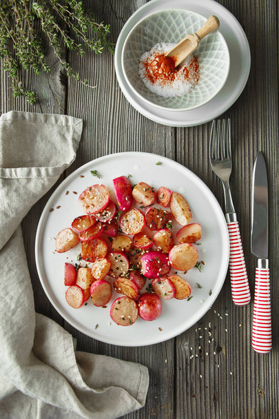 Beautiful roasted radishes served with thyme and sesame seeds in - Foto, Imagem