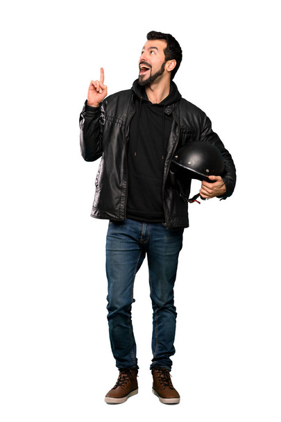 Full-length shot of Biker man thinking an idea pointing the finger up over isolated white background - Photo, image