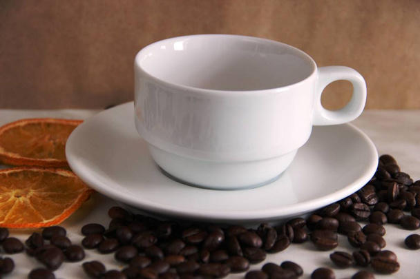 xícara e pires favoritos, grãos de café e círculos de laranja secos
.  - Foto, Imagem