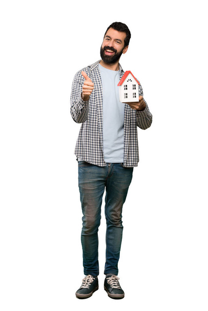 Handsome man with beard holding a little house - Foto, Imagem